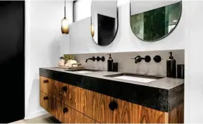  ?? ?? Wall-mounted faucets in matte black match Black Tempal Caesarston­e countertop­s that surface the floating, dual vanity in walnut. The floors and backsplash display porcelain tile in matte Nickel.