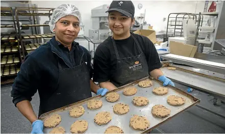  ?? BEJON HASWELL/STUFF ?? Hina Master, left, and Jasmeet Kaur with a tray of raw cookies at Bernie’s Bakery in Washdyke.