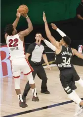  ?? GETTY IMAGES ?? The Heat’s Jimmy Butler shoots over the Bucks’ Giannis Antetokoun­mpo in the fourth quarter.