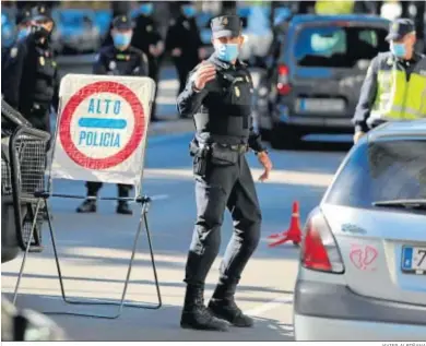  ?? JAVIER ALBIÑANA ?? Un agente de la Policía Nacional efectúa labor de control de las salidas de los vehículos en Málaga.