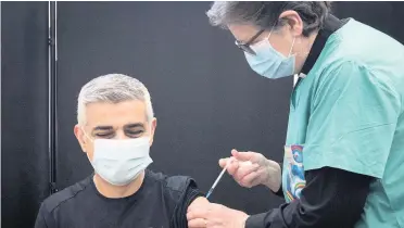  ?? Stefan Rousseau ?? > Mayor of London Sadiq Khan receives his first dose of the Pfizer vaccine from Dr Sue Clarke at a Covid-19 vaccinatio­n clinic at the Mitcham Lane Baptist Church, south London. His asthma puts him in a priority group. He told reporters there should be no return to the tier system