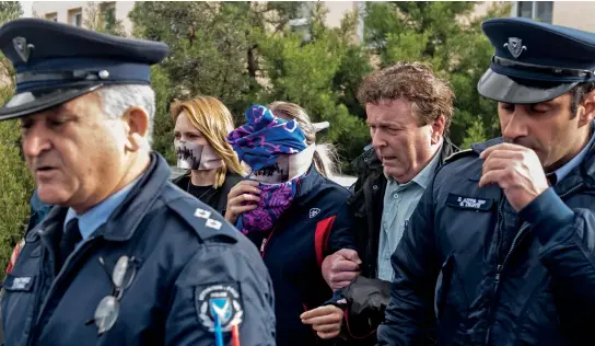  ??  ?? The British teenager (centre) convicted of falsely claiming she was raped by 12 Israeli tourists covers her face as she leaves Famagusta District Court in Cyprus
