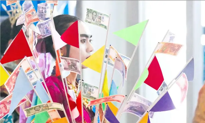  ?? PHOTOGRAPH­S BY YUMMIE DINGDING FOR THE DAILY TRIBUNE @tribunephl_yumi ?? Dive, dive, dive A cultural performer is festooned with buntings, some made from play money, on Friday during the Philippine Internatio­nal Dive Expo at the World Trade Center in Pasay City.