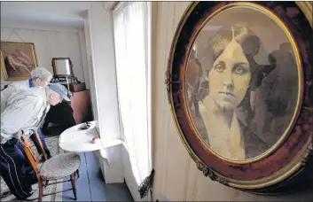  ?? AP PHOTO ?? In this May 17, 2018 photo, Samuel Ruggiero, of Erie, Penn., front left, examines the desk where author Louisa May Alcott sat while writing the book “Little Women” at Orchard House, in Concord, Mass. Since “Little Women” was published 150 years ago,...