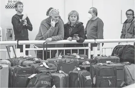  ?? KAMIL KRZACZYNSK­I/ AFP VIA GETTY IMAGES ?? Stranded Southwest Airlines passengers look for their luggage in the baggage claim area at Chicago Midway Internatio­nal Airport on Dec. 28, 2022.