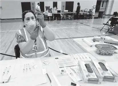  ?? DYLAN SLAGLE/BALTIMORE SUN MEDIA ?? Stacy Hann, an LPN, prepares doses of the Moderna COVID-19 vaccine Friday at in Westminste­r.