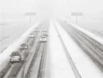  ?? Yi-Chin Lee / Staff photograph­er ?? Motorists drive through the snow on Texas 6 in College Station, which got 4.5 inches of powder.