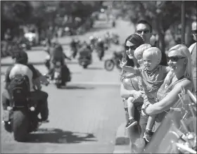  ?? NWA Democrat-Gazette/ANDY SHUPE ?? Colby Myers, 2, (center) and his twin brother Emmett, wave at motorcycle­s Saturday while spending the day with their mother, Audra Myers (right) and friend Kim White, both of Rogers, during the annual Bikes, Blues &amp; BBQ motorcycle rally in Fayettevil­le.