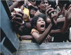  ?? — Reuters ?? Rohingya refugees scuffle as they wait to receive aid in Cox’s Bazar, Bangladesh, on Sunday.