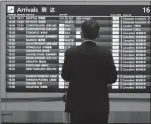  ?? The Associated Press ?? A driver looks at an arrivals board of cancelled flights at Haneda Internatio­nal Airport in Tokyo, Friday.