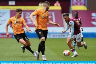  ?? — AFP ?? BIRMINGHAM: Aston Villa’s English midfielder Jack Grealish (R) runs with the ball during the English Premier League football match between Aston Villa and Wolverhamp­ton Wanderers at Villa Park in Birmingham, central England on June 27, 2020.