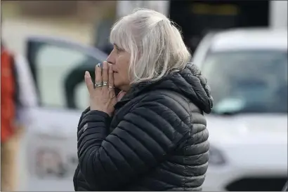  ?? ROBERT F. BUKATY, FILE — THE ASSOCIATED PRESS ?? A woman reacts at the scene of a multiple shooting, Tuesday in Bowdoin, Maine. Four people were found fatally shot in a Maine home shortly before gunfire injured three others on a busy highway 25 miles away in a pair of crimes that were linked, state police said.