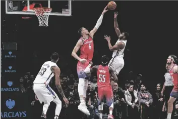  ?? BEBETO MATTHEWS/AP ?? WASHINGTON WIZARDS CENTER KRISTAPS PORZINGIS (SECOND FROM LEFT) attempts to block Brooklyn Nets guard Cam Thomas, during the second half of a game on Saturday in New York.