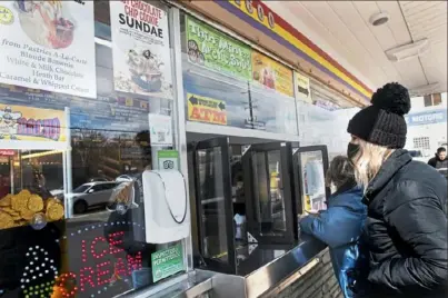  ?? Pam Panchak/Post-Gazette ?? Kristen Jeke, of Wexford, and Trudy Baumgarten, of Scott, were Page Dairy Mart’s first customers of the year, along with their co-worker Vicki Holbrook, of Cheswick. They stopped by the iconic South Side ice cream shop on its opening day of 2021.
