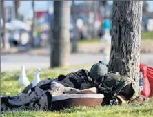  ??  ?? A HOMELESS MAN sleeps under a palm tree near the Venice boardwalk. Encampment­s have sprung up around the city.