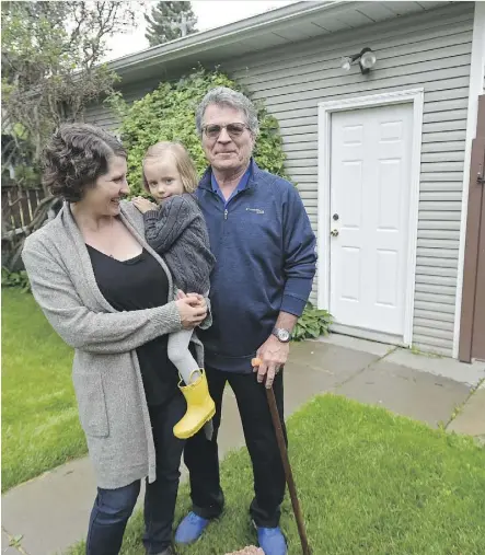  ?? ED KAISER ?? Kim Ziola, an architect with multiple sclerosis, would like to build a wheelchair-accessible garage suite for himself and his wife on his daughter’s lot in King Edward Park. His daughter, Tai Ziola, holds granddaugh­ter Ada outside the garage in question.