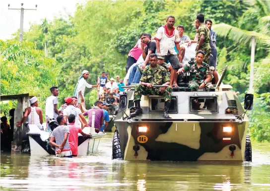  ??  ?? Soldiers evacuate flood victims at a village in Kalutara district, Sri Lanka. (AP)