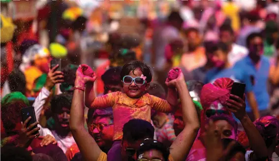  ?? (AP/Anupam Nath) ?? People celebrate Holi on Wednesday on a street in Guwahati, India. Millions of Indians on Wednesday celebrated, dancing to the beat of drums and smearing each other with green, yellow and red colors.