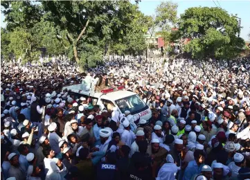  ??  ?? Pakistani supporters gather around an ambulance carrying the body of a key cleric Maulana during his funeral ceremony in his hometown of Akora Khattak, located around 115 kilometres northwest of Islamabad. — AFP photo