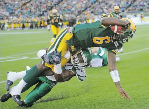  ?? LARRY WONG/ EDMONTON JOURNAL ?? Edmonton Eskimos quarterbac­k Jacory Harris dives into the end zone for a touchdown as he’s being tackled by Saskatchew­an Roughrider­s linebacker Anthony Heygood during CFL pre-season action at Commonweal­th Stadium on Friday night.