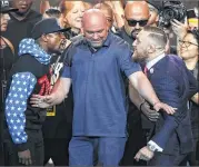  ?? JAE C. HONG / ASSOCIATED PRESS ?? UFC President Dana White separates Floyd Mayweather Jr. (left) and Conor McGregor during verbal sparring at Tuesday’s news conference.