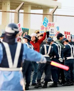  ??  ?? Protesters hold slogans during a demonstrat­ion near the gate of US Marine Corps’ camp Schwab in Nago, Okinawa prefecture. — AFP photo