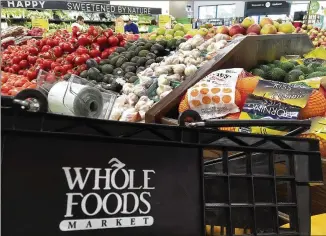  ?? ELISE AMENDOLA / AP ?? Amazon plans to buy Whole Foods in a deal valued at about $13.7 billion. The two companies have not yet detailed how their proposed union might change the experience for customers, but regulators likely won’t determine that the online shopping giant...