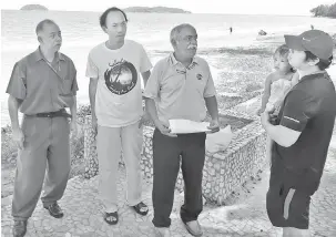  ??  ?? HENTI PROJEK: Muthu (tengah) sempat berbual dengan pengunjung dan berkongsi pandangan tentang keadaan di Pantai Tanjung Aru.