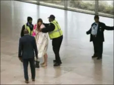  ?? KEVIN WOLF — THE ASSOCIATED PRESS ?? National Gallery of Art security cover Radical Matriarchy member Laura Newman with a blanket after she removed her clothes and sang during a protest in the museum, Thursday in Washington.