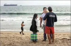 ?? Mel Melcon Los Angeles Times ?? A MAN and his daughter react to being told by a lifeguard to keep out of the water at Dockweiler State Beach in Playa del Ray after a sewage spill.