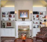  ??  ?? A vaulted ceiling soars above the living room, which centers around a marble-trimmed  replace.