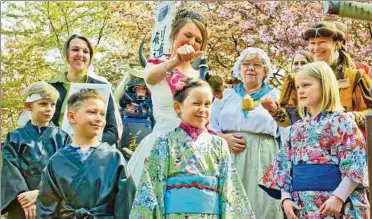  ??  ?? Sakura Leni verzog das Gesicht, als ihr die Rosenkönig­in Julia Ehrlich bei der Taufzeremo­nie Teichwasse­r auf dem Kopf träufelte. Links neben ihr steht Lennart, der neue Samurai.