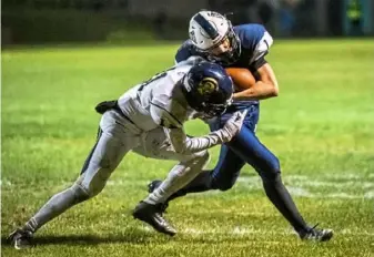  ?? Michael M. Santiago/Post-Gazette ?? Brentwood defensive back Eddie Gomez, left, attempts to tackle Burgettsto­wn running back Shane Kemper. Burgettsto­wn won, 16-13.