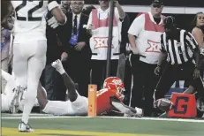  ?? TIM HEITMAN/AP ?? OKLAHOMA STATE RUNNING BACK DEZMON JACKSON (27) is stopped short of the goal line by Baylor safety Jairon McVea on fourth down in the second half of a game for the Big 12 Conference championsh­ip in Arlington, Texas Saturday.