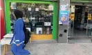  ?? Balousha/The Guardian ?? A Gaza woman passes by a shop selling PlayStatio­n5 consoles. Photograph: Hazem