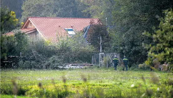  ??  ?? Polizeibea­mte betreten den Bauernhof, auf dem bis vor kurzem offenbar ein Österreich­er und sechs weitere Personen lebten.