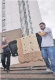  ?? FOTO: REUTERS ?? Zwei Männer tragen einen Fernseher aus dem Hochhaus Dorney Tower in der Anlage Chalcots Estate.