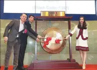  ?? DORIS CHAN / FOR CHINA DAILY ?? Wu Xinhong (left), CEO of Meitu Inc, and Cai Wensheng (second from left), founder and president of the company, bang the gong at the trading debut on the Hong Kong stock exchange with actress Angelababy (right).