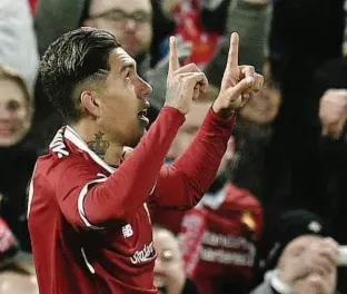  ?? Oli Scarff/AFP ?? Roberto Firmino comemora o seu gol, o segundo do Liverpool sobre o City; o atacante brasileiro deu um leve toque por cima do goleiro Éderson para marcar