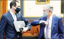  ??  ?? Treasury Secretary Steven Mnuchin (left), greets Federal Reserve Chair Jerome Powell with an elbow bump before the start of a House Financial Services Committee hearing about the government’s emergency aid to the economy in response to the coronaviru­s on Capitol Hill in Washington on Sept 22. (AP)