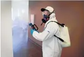  ??  ?? A technician with United Restoratio­n uses a fogging machine loaded with hospital-grade disinfecta­nt.