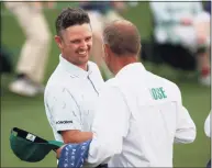  ?? Kevin C. Cox / Getty Images ?? Justin Rose of England fist bumps his caddie, David Clark, after a first-round 65 at the Masters on Thursday at Augusta National Golf Club.