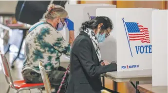  ?? KAMIL KRZACZYNSK­I/AFP VIA GETTY IMAGES ?? People vote inside City Hall in Kenosha, Wisconsin, on Oct. 20, the first day of in-person early voting in Wisconsin.