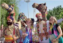  ?? — PTI ?? Foreigners with Rajasthani folk artistes during an event to promote tourism in Bikaner on Wednesday.