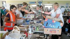  ?? GETTY IMAGES ?? Volunteers sort food for those evacuated from their homes due to the fires.