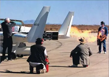  ?? Gina Ferazzi Los Angeles Times ?? CREW MEMBERS watch as alcohol is burned off the engines of Xcor’s EZ Rocket in 2001. Over time, the company found it had underestim­ated the complexity of its space tourism project and the necessary finances.