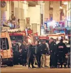  ??  ?? Police officers and rescue workers attend to victims of the horrific attacks in six different locations across Paris by Islamic State militants.