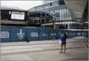  ?? ASSOCIATED PRESS FILE PHOTO ?? A woman watches a hockey game on the big screen just outside the bubble at the NHL Western Conference Stanley Cup hockey playoffs in Edmonton, Alberta.