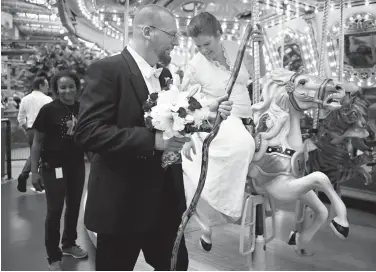  ?? Richard Tsong-Taatarii /Star Tribune via Associated Press ?? n David and Elizabeth Weinlick pose for a photograph Aug. 18 after renewing their wedding vows at the Mall of America in Bloomingto­n, Minn. The couple began their life together through an arranged marriage nearly 20 years ago. The occasion will also be...