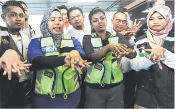  ??  ?? Medical personnel demonstrat­e to humanitari­an aid mission volunteers on how to wash their hands with sanitizer on board Nautical Aliya. — Bernama photo